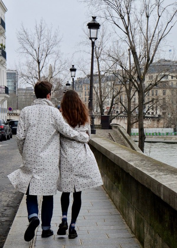 couple walking beside the river in Paris