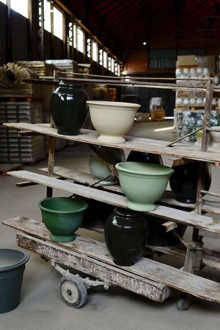 some glazed pots on wooden storage racks