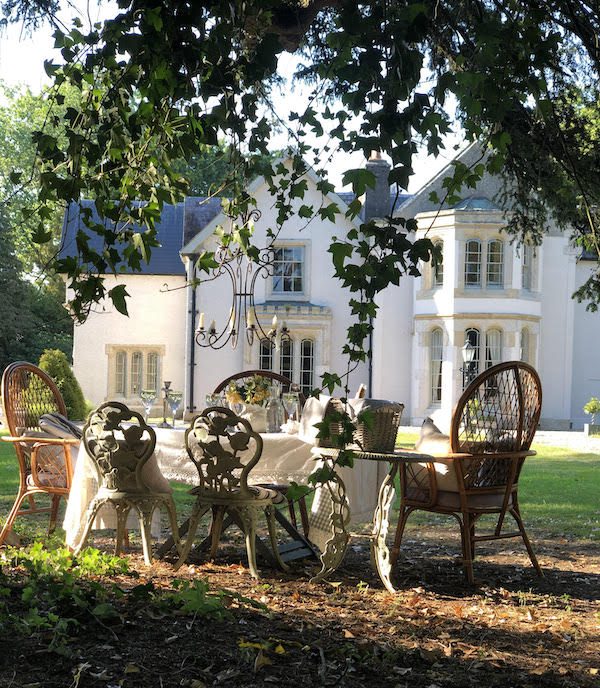 grand white country manor with tablescape on lawn