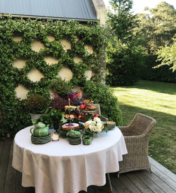 gorgeous charming tablescape outside of patio with ivy trellis