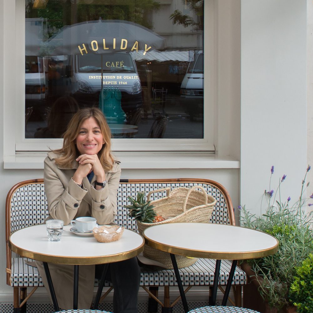 a shot of a woman sitting outside at a paris cafe