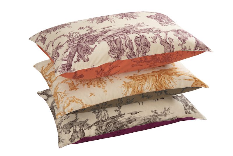 three toile de jouy patterned cushions