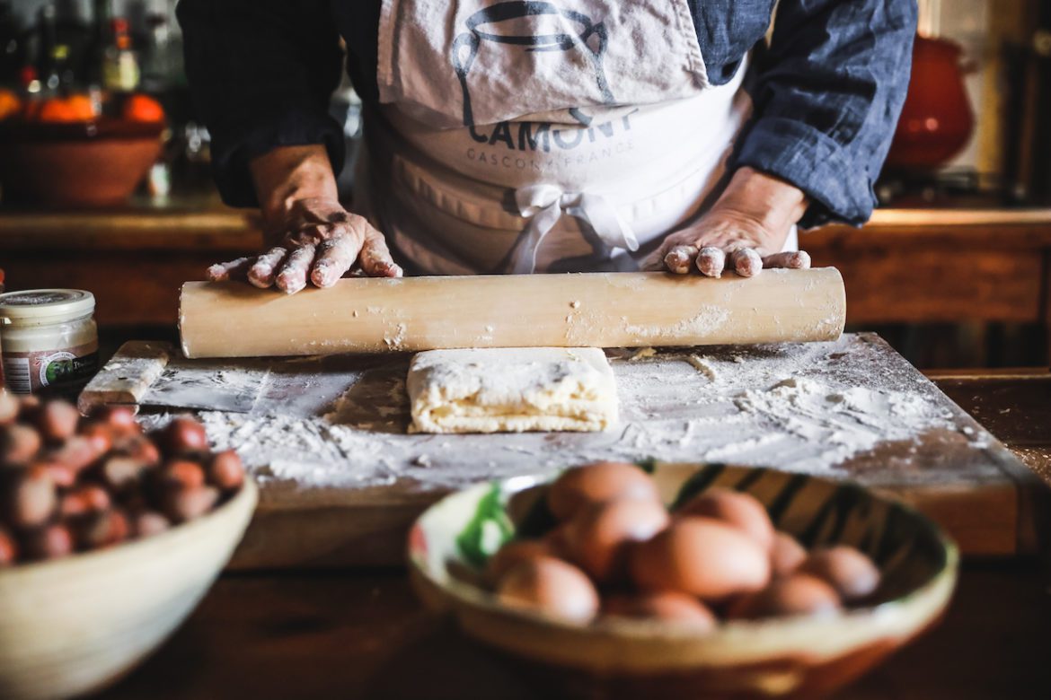 hands rolling a pin over pastry