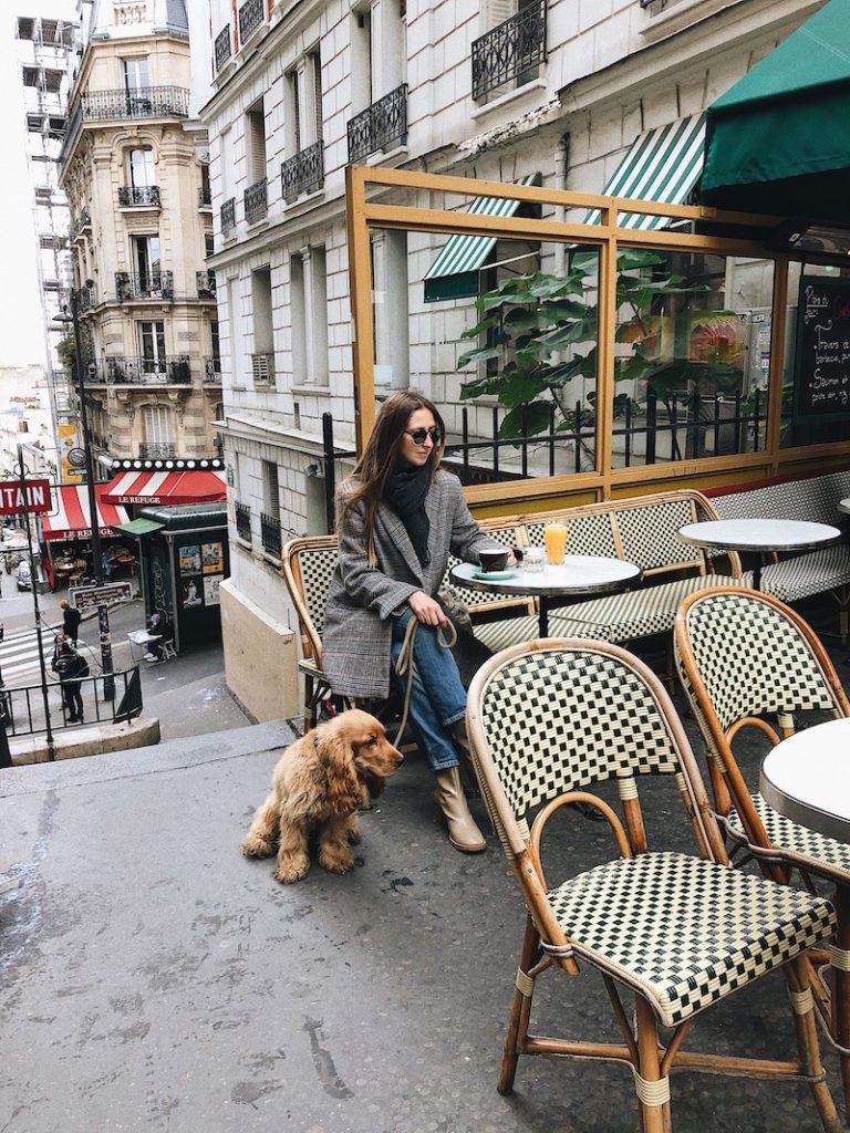 a woman and a puppy on a terrace in Paris