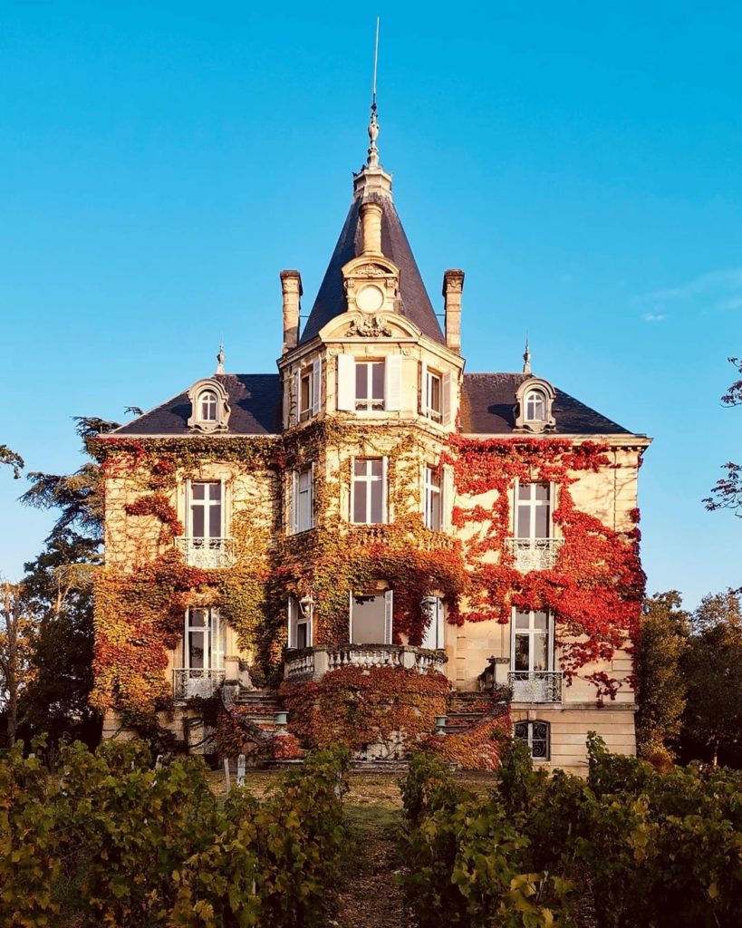 french chateau covered in red ivy in fall