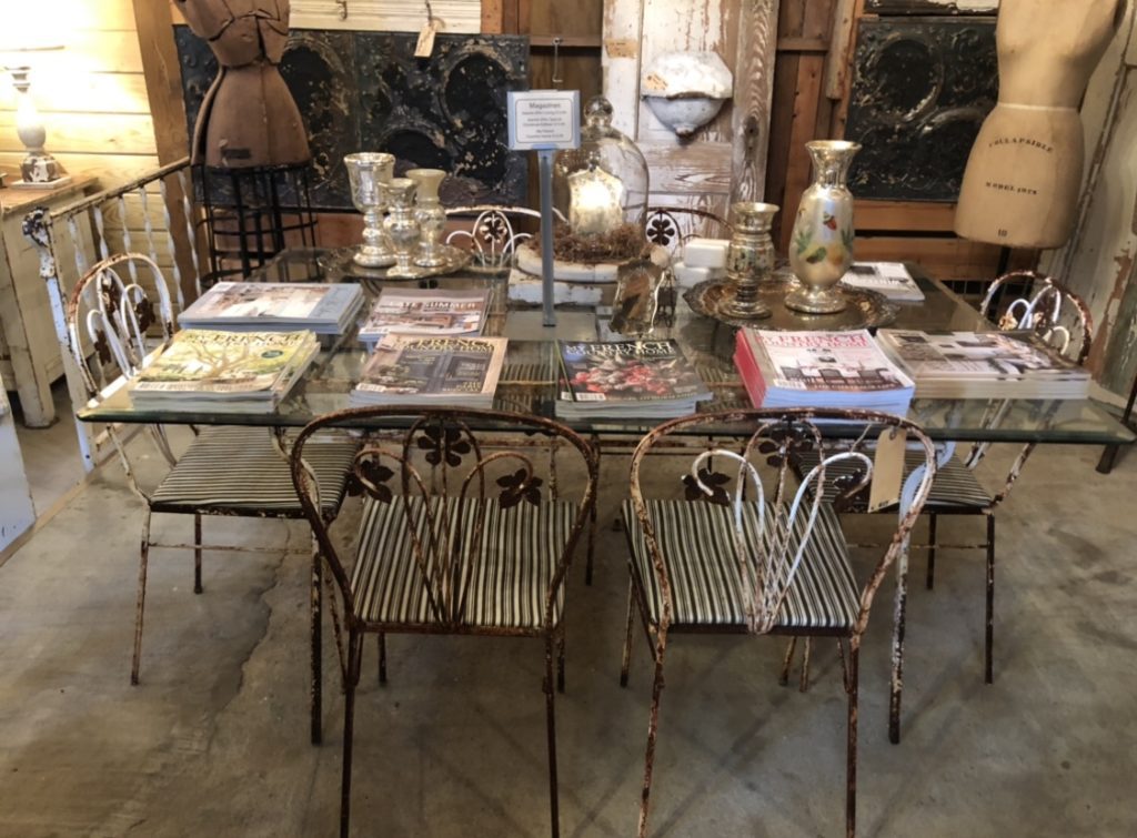 a rustic iron table with magazines laid out on it