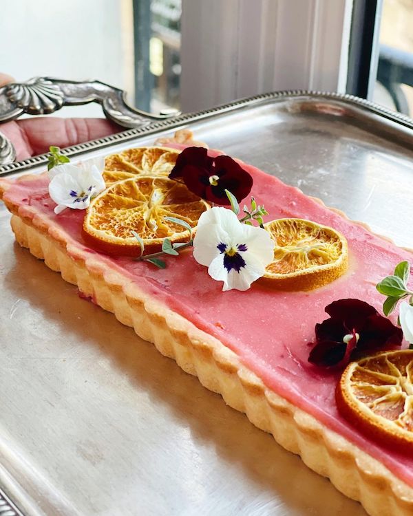 fruit tart with flowers and orange slices
