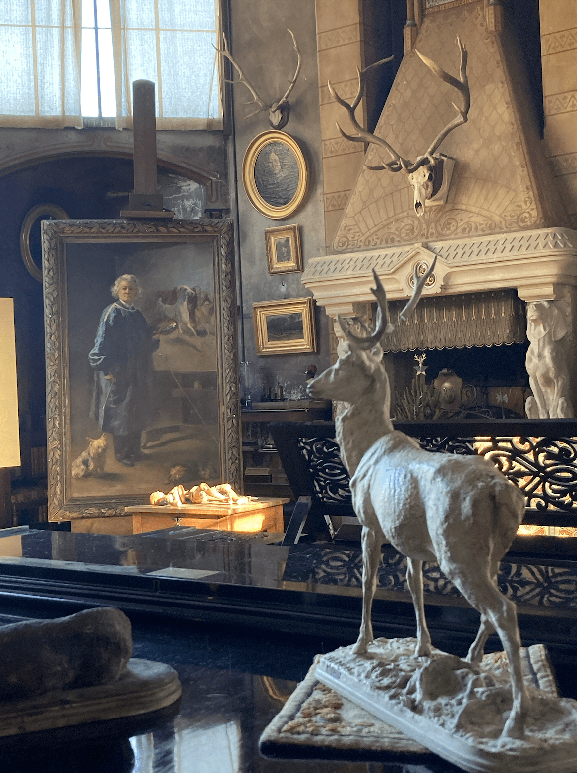 fireplace with painting and deer statue