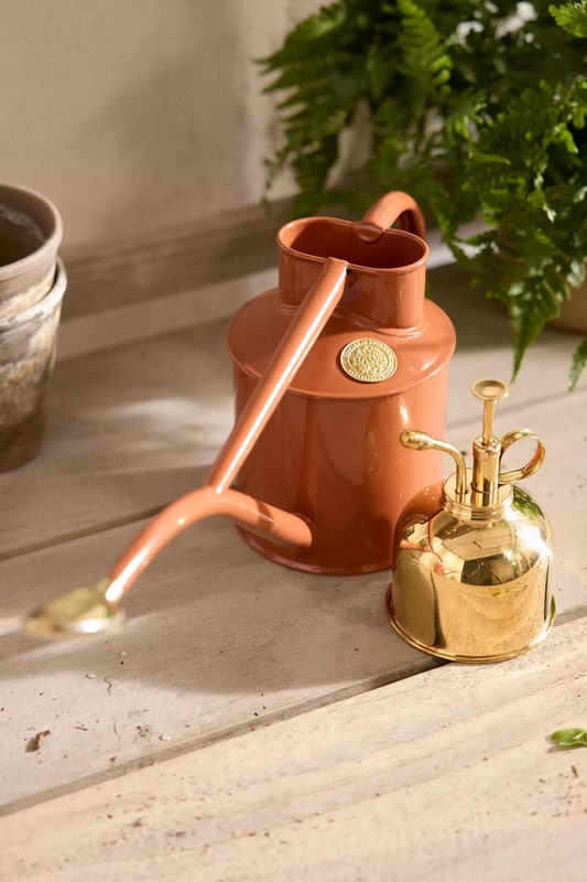 Terracotta colored Haws Rowley Ripple Watering Can and mister.