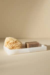 Organizational stone bath tray with a natural sponge and soap. 