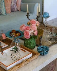 Coffee table with freshly cut flowers, candles, and organized vases. 