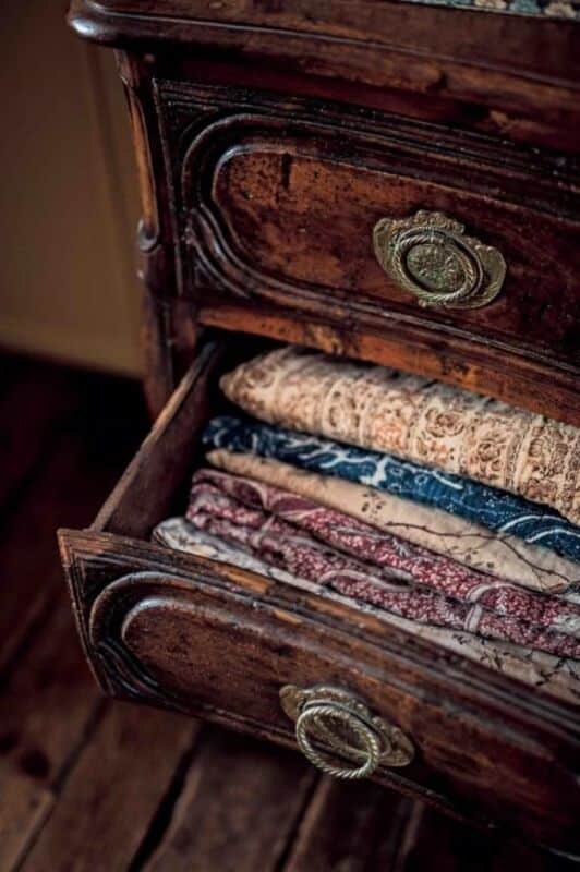 Antique French chest of drawers with folded linens.