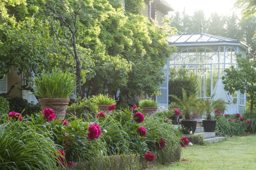 Jardins du Grand Courtoiseau in Triguères, France with lush greenery and blooming magenta dahlias.