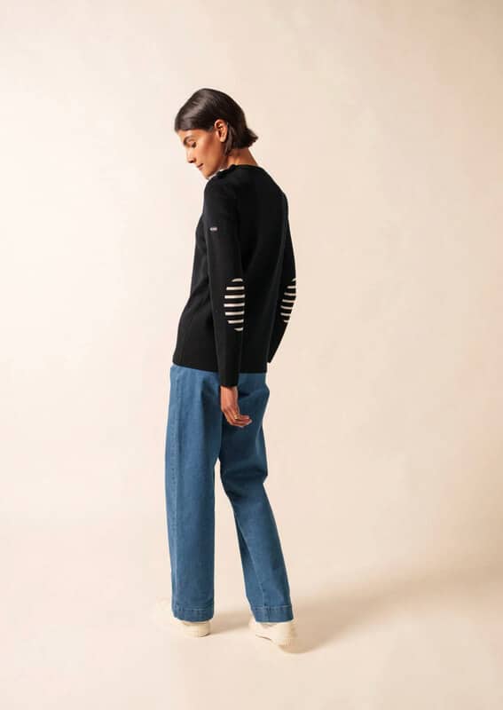 Woman in a navy blue wool Saint James sweater, featuring striped elbow patches.