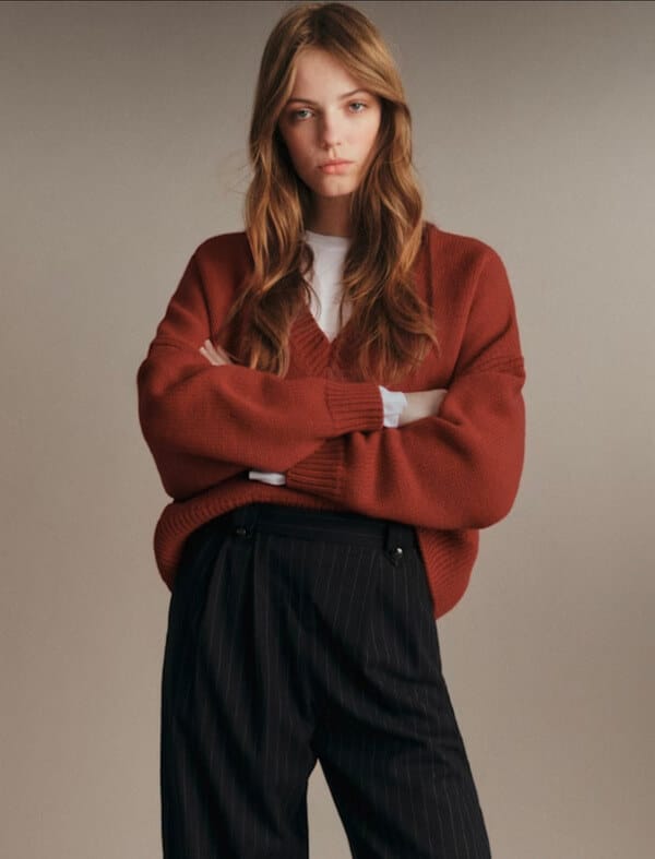 Slouchy Sézane rust knit sweater styled with a white t shirt and black trousers.